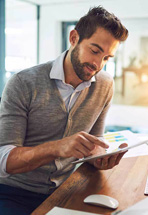 Business professional using his tablet to check his financial numbers